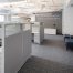 Corporate interior design with workstations and wall quote: Once a year go someplace you've never been before